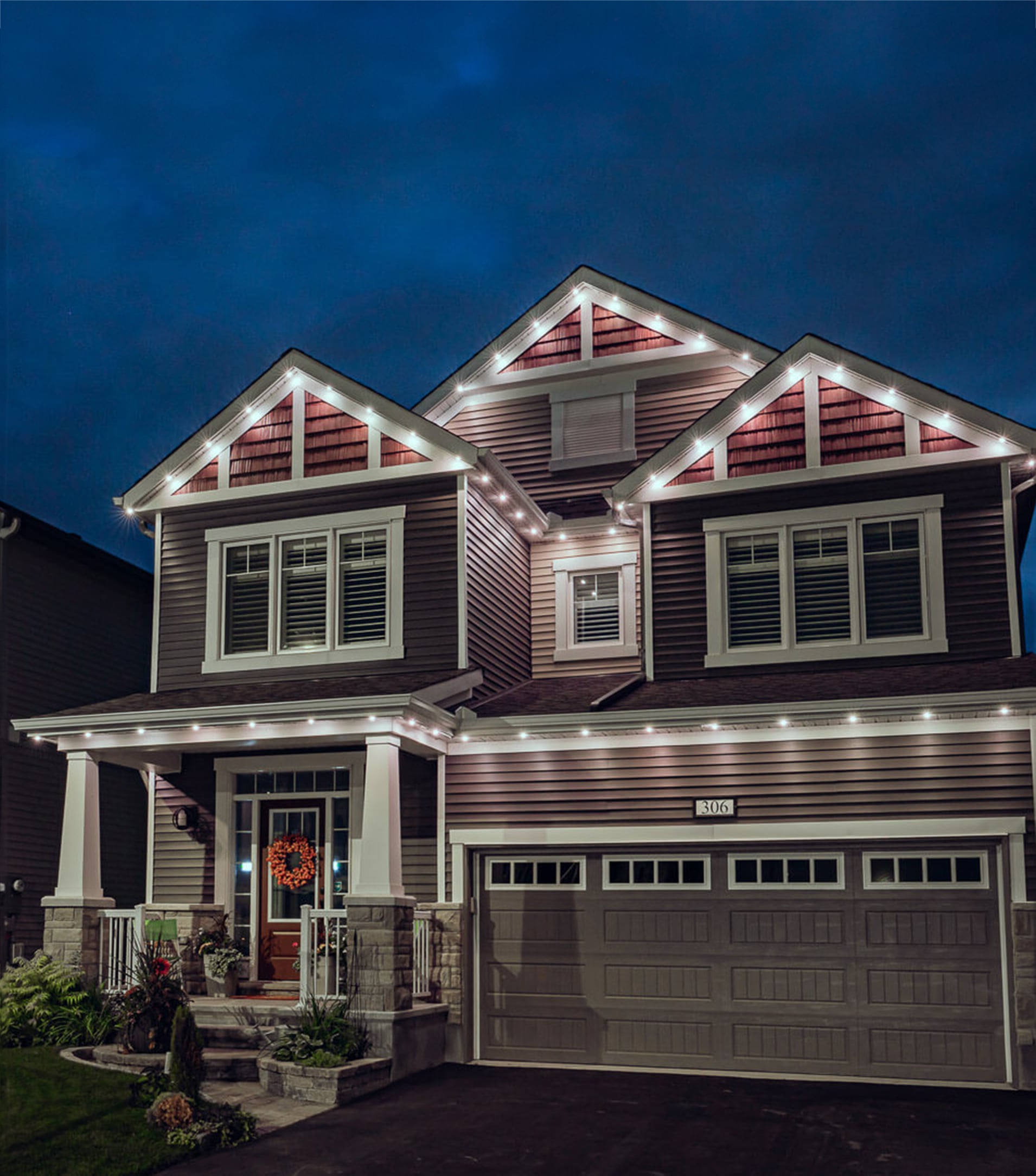 Custom outdoor LED lighting by Shiloh Valley Lighting on a two-story home at twilight in St. Louis, highlighting the elegant and permanent installation service.