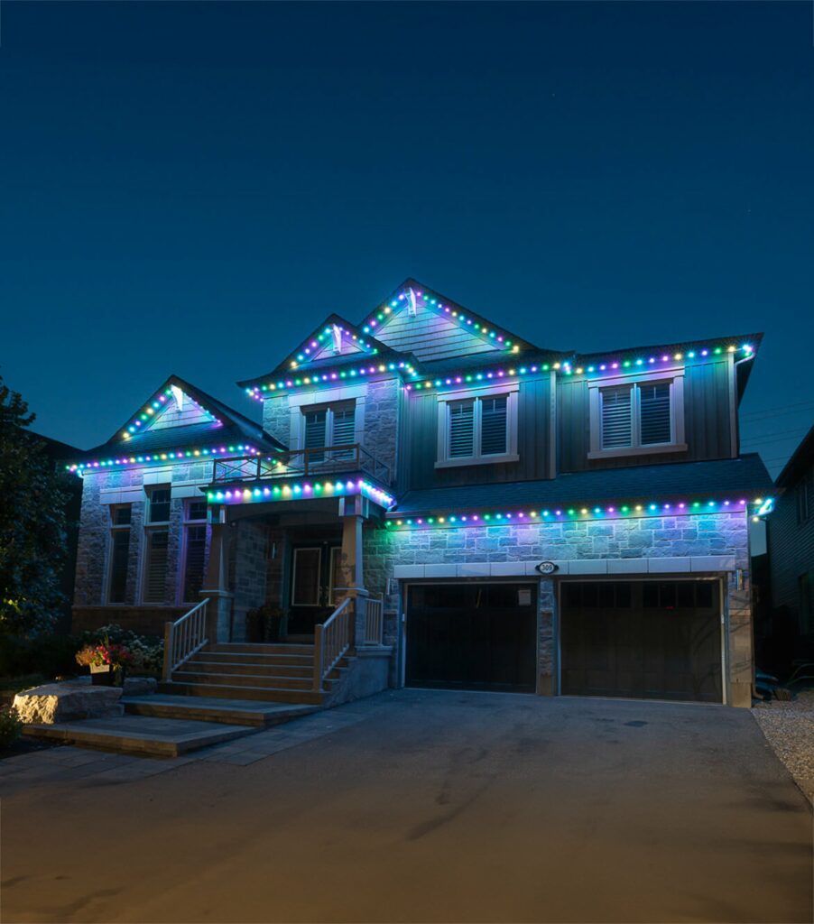 Energy-efficient LED lights by Shiloh Valley Lighting adorn the roofline and windows of a modern two-story home, showcasing a vibrant array of customizable colors that enhance the property's nighttime curb appeal.